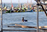 Nelayan menurunkan peralatan dari perahu saat tidak melaut di Pelabuhan Tanjung, Sumenep, Jawa Timur, Kamis (25/7/2019). Sejak sepekan lalu sebagian besar nelayan di daerah itu tidak melaut selain karena ombak dan angin juga karena tingginya suhu permukaan laut yang menyebabkan minimnya ikan. Antara Jatim/Saiful Bahri/zk.