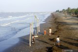 Sejumlah anak bermain sambil menikmati suasana di Pantai Samudera Baru, Karawang, Jawa Barat, Kamis (25/7/2019). Pemerintah Kabupaten Karawang menutup sementara tempat wisata pantai di Karawang untuk mencengah dampak air laut pada kesehatan masyarakat karena air laut tercemar tumpahan minyak mentah (Oil Spill) milik Pertamina yang tercecer di pesisir laut Karawang. ANTARA JABAR/M Ibnu Chazar/agr