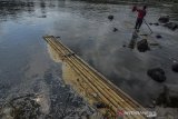 Warga menyeberangi Sungai Ciwulan menggunakan rakit di Desa Papayan, Kabupaten Tasikmalaya, Jawa Barat, Kamis (25/7/2019). Sepanjang aliran Sungai Ciwulan terdampak pencemaran sungai yang diduga berasal dari limbah pabrik, penambangan pasir ilegal, dan sampah ke sungai sehingga mengakibatkan air sungai keruh dan merusak ekosistem sungai. ANTARA JABAR/Adeng Bustomi/agr
