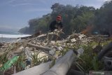 Penggiat Pokdarwis (Kelompok Sadar Wisata) membakar sampah kayu dan plastik yang mengotori pesisir Pantai Jung Pakis, Tulungagung, Jawa Timur, Kamis (25/7/2019). Kegiatan itu dilakukan secara swadaya untuk menjaga kebersihan pantai setempat. Antara Jatim/Destyan Sujarwoko/zk.