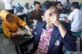 Petugas mengambil sampel darah dari tangan mahasiswa peserta Kuliah Kerja Nyata (KKN) di STKIP Tulungagung, Tulungagung, Jawa Timur, Rabu (24/7/2019). Sebanyak 206 mahasiswa peserta KKN di kampus itu diwajibkan mengikuti test HIV/AIDS untuk mendeteksi ada/tidaknya mahasiswa yang mengidap HIVAIDS. Antara Jatim/Destyan Sujarwoko/zk.