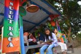Bocah membaca buku dan komik di Pos Keamanan Keliling (Pos Kamling) atau Pos Ronda di Desa Mojoduwur, Kecamatan Mojowarno, Kabupaten Jombang, Jawa Timur, Kamis (25/7/2019). Pemuda desa setempat menyulap Pos Kamling menjadi area bermain dan membaca 