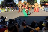 Fotografer memotret model yang  memperagakan kostum ethnik pada gelaran Banyuwangi Ethno Carnival di Taman Blambangan, Banyuwangi, Jawa Timur, Sabtu (27/7/2019). Pagelaran busana ethnik yang masuk dalam kalender 100 top even nasional itu, mengangkat tema The King Of Blambangan yang menceritakan tentang kejayaan kerajaan Blambangan pada masanya. Antara Jatim/Budi Candra Setya/zk.