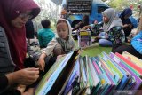 Warga membaca buku koleksi mobil perpustakaan keliling secara gratis di kawasan Taman Hijau, Kediri, Jawa Timur, Minggu (28/7/2019). Pemerintah daerah setempat mengoperasikan sejumlah perpustakaan keliling di berbagai titik keramaian untuk mempermudah akses warga mendapatkan bahan bacaan bermutu guna mendorong minat baca masyarakat. Antara Jatim/Prasetia Fauzani/zk.