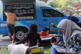 Warga membaca buku koleksi mobil perpustakaan keliling secara gratis di kawasan Taman Hijau, Kediri, Jawa Timur, Minggu (28/7/2019). Pemerintah daerah setempat mengoperasikan sejumlah perpustakaan keliling di berbagai titik keramaian untuk mempermudah akses warga mendapatkan bahan bacaan bermutu guna mendorong minat baca masyarakat. Antara Jatim/Prasetia Fauzani/zk.