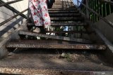 Warga menuruni tangga pada jembatan penyeberangan orang (JPO) yang kondisinya rusak di Kota Kediri, Jawa Timur, Senin (29/7/2019). JPO satu-satunya di Kediri tersebut rusak dan membahayakan pengguna. Antara Jatim/Prasetia Fauzani/zk