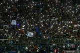 Suporter Arema FC, (Aremania) beratraksi dengan menyalakan lampu gawai usai pertandingan Liga I antara Arema melawan Persib Bandung di stadion Kanjuruhan, Malang, Jawa Timur, Selasa (30/7/2019). Arema mengalahkan Persib dengan skor akhir 5-1. Antara Jatim/Ari Bowo Sucipto/zk.