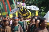 Sejumlah pemuda membawa patung berbentuk lebah saat kirab budaya di kawasan Kampung Madu Desa Bringin, Kediri, Jawa Timur, Kamis (1/8/2019). Kirab budaya dan pembagian sebanyak 2019 botol madu 50 mililiter tersebut sebagai perwujudan rasa syukur melimpahnya hasil panen madu sekaligus sebagai media promosi wisata Kampung Madu. Antara Jatim/Prasetia Fauzani/zk.