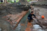 Arkeolog Balai Pelestarian Cagar Budaya (BPCB) Jatim, Wicaksono Dwi Nugroho melakukan ekskavasi survei penyelamatan di situs Dusun Sumberbeji, Desa Kesamben, Kecamatan Ngoro, Jombang, Jawa Timur, Kamis (1/8/2019). BPCB Jatim mengidentifikasi saluran air kuno di Dusun Sumberbeji tersebut mengarah ke suatu struktur yang cenderung merupakan sebuah petirtaan peninggalan kerajaan Majapahit dengan ditemukannya pancuran atau jaladwara dari batu andesit berbentuk menyerupai kepala naga. Antara Jatim/Syaiful Arif/zk.