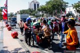 Pengemudi becak motor (bentor) menurunkan penumpang rekannya saat aksi unjuk rasa depan Kantor Gubernur Jatim, Surabaya, Jawa Timur, Jumat (2/8/2019). Dalam aksi yang diikuti oleh ratusan pengemudi bentor tersebut menuntut pemerintah menolak rencana penertiban bentor dan membentuk Perda perlindungan bentor. Antara Jatim/Umarul Faruq/zk