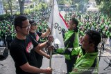 VP Regional Gojek Jawa Barat dan Banten Becquini Akbar (kiri) dan Regional Operations Head Gojek Jawa Barat dan Banten Bambang Adi Wirawan (kedua kiri) menerima bendera dari Mitra Gojek pada acara Festival Apresiasi Mitra Gojek di Armor Kopi, Bandung, Jawa Barat, Sabtu (3/8/2019). Sedikitnya 2000 Mitra Driver Gojek memeriahkan acara yang bertujuan untuk apresiasi sekaligus mengenalkan logo dan membagikan jaket baru sebagai upaya meningkatkan semangat, inovasi dan pelayanan kepada konsumen di Indonesia. ANTARA FOTO/Novrian Arbi/agr