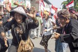 Sejumlah warga menari saat mengikuti kirab merah putih di kawasan Stadion Singaperbangsa, Karawang, Jawa Barat, Sabtu (3/8/2019). Kirab merah putih tersebut bertujuan untuk menyatukan semua elemen masyarakat sebagai bentuk rasa cinta tanah air dan menjaga persatuan bangsa Indonesia. ANTARA FOTO/M Ibnu Chazar/agr