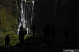 Pengunjung mengamati Air Terjun Tumpak Sewu di Lumajang, Jawa Timur, Minggu (4/8/2019). Air Terjun Tumpak Sewu merupakan air terjun yang berketinggian sekitar 120 meter yang berada di perbatasan Lumajang dengan Malang. Antara Jatim/Zabur Karuru