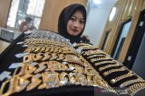 Pekerja menunjukan perhiasan emas di Toko emas ACC Mandiri, Banjarsari, Kabupaten Ciamis, Jawa Barat, Minggu (4/8/2019). Berdasarkan data yang dirilis oleh World Gold Council tahun 2018, Indonesia menduduki peringkat kedelapan dengan permintaan emas terbesar di dunia dengan total 64,1 metrik ton, yang terbagi menjadi 41,9 metrik ton dijadikan perhiasan emas dan 22,2 metrik ton emas batangan serta emas koin. ANTARA FOTO/Adeng Bustomi/agr