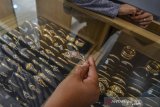 Pekerja melayani pembeli perhiasan emas di Toko emas ACC Mandiri, Banjarsari, Kabupaten Ciamis, Jawa Barat, Minggu (4/8/2019). Berdasarkan data yang dirilis oleh World Gold Council tahun 2018, Indonesia menduduki peringkat kedelapan dengan permintaan emas terbesar di dunia dengan total 64,1 metrik ton, yang terbagi menjadi 41,9 metrik ton dijadikan perhiasan emas dan 22,2 metrik ton emas batangan serta emas koin. ANTARA FOTO/Adeng Bustomi/agr