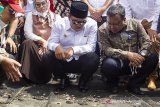 Gubernur Jawa Barat Ridwan Kamil (tengah) didampingi Bupati Karawang Cellica Nurrachadiana (kiri) dan Direktur Utama Pertamina EP Nanang Abdul Manaf (kanan) meninjau lokasi terdampak tumpahan minyak mentah milik Pertamina di pesisir Pantai Cemarajaya, Cibuaya, Karawang, Jawa Barat, Rabu (7/8/2019). Gubernur Jawa Barat Ridwan Kamil mengatakan telah memerintahkan pemerintah daerah mencatat semua kerugian untuk diselesaikan dalam 10 sampai 14 hari dan meminta Pertamina untuk memaparkan kembali rencana kontigensi di masa depan serta akan meneliti lingkungan yang terdapak tumpahan minyak mentah milik Pertamina di Pesisir laut Karawang. ANTARA FOTO/M Ibnu Chazar/agr