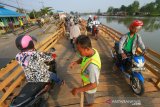 Warga mengatur lalulintas di jembatan darurat Sungai Gardu Banjarmasin, Kalimantan Selatan, Rabu (7/8/2019).Proyek pembangunan jembatan penghubung antara kota Banjarmasin dan kabupaten Banjar dengan anggaran 17,5 miliar mulai dikerjakan.Foto Antaranews Kalsel/Bayu Pratama S.