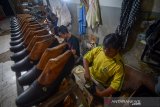 Pengrajin menyelesaikan produksi sepatu di Sentra Sepatu Cibaduyut, Bandung, Jawa Barat, Rabu (7/8/2019). Asosiasi Persepatuan Indonesia (Asprisindo) memproyeksikan volume produksi sepatu nasional pada 2019 akan tumbuh sekitar 5 persen, di sisi lain, Badan usat Statistik (BPS) mencatat kinerja ekspor alas kaki pada kuartal I/2019 naik hingga 8,66 persen. ANTARA JABAR/Raisan Al Farisi/agr