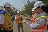 PEMBAYARAN TOL TANPA HENTI. Kepala Badan Pengatur Jalan Tol Kementrian PUPR Danang Parikesit (kiri) menyimak penjelasan Tim Teknis PT Marga Mandalasakti saat meninjau ujicoba penerapan sistem pembayaran tol tanpa henti (electronic collection free flow) di Serang, Banten, Kamis (8/8/2019). Menurut Danang, Pemerintah Pusat secepatnya akan mengkaji penerapan sistem pembayaran tol tanpa henti hingga maksimal dalam kecepatan mobil 40 km/jam itu secara menyeluruh untuk segera dilaksanakan guna menghindari antrian panjang saat pembayaran tol dan lebih memperlancar arus kendaraan. ANTARA FOTO/Asep Fathulrahman/ANTARA FOTO/ASEP FATHULRAHMAN (ANTARA FOTO/ASEP FATHULRAHMAN)