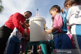 Wali Kota Banda Aceh Aminullah Usman (kiri) mengarahkan pelajar Taman Kanak-kanak (TK) mencuci tangan pakai sabun pada peringatan hari anak nasional 2019 di Banda Aceh, Aceh, Kamis (8/8/2019). Gerakan mencuci tangan dengan sabun menjadi ajang kampanye perilaku hidup bersih dan sehat menuju Indonesia sehat. (Antara Aceh / Irwansyah Putra)