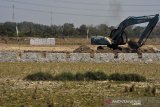 Petani mencangkul lahan mereka di samping batas area pengembang yang sedang membangun kompleks perumahan di Kasemen, Serang, Banten, Kamis (8/8/2019). 