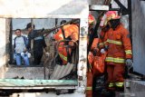 Petugas mengevakuasi jenasah korban kebakaran di Jalan Kedinding Tengah III B, Surabaya, Jawa Timur, Jumat (9/8/2019). Sekitar sepuluh kendaraan pemadam kebakaran dikerahkan untuk memadamkan kebakaran yang menewaskan satu orang penghuni rumah berinisial K (70) itu. Antara Jatim/Didik Suhartono/ZK