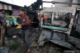 Petugas memasang garis polisi di area rumah yang terbakar di Jalan Kedinding Tengah III B, Surabaya, Jawa Timur, Jumat (9/8/2019). Sekitar sepuluh kendaraan pemadam kebakaran dikerahkan untuk memadamkan kebakaran yang menewaskan satu orang penghuni rumah berinisial K (70) itu. Antara Jatim/Didik Suhartono/ZK