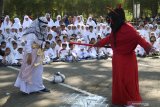 Guru memperagakan nabi Ismail diganggu setan di hadapan sejumlah anak saat menceritakan asal mula ibadah kurban dan haji di Tirtoyoso, Kota Kediri, Jawa Timur, Jumat (9/8/2019). Kegiatan yang diikuti sedikitnya 300 anak tingkat PAUD dan TK yayasan taman pendidikan Rahmat tersebut bertujuan memperkenalkan rukun islam ke lima kepada anak sejak dini. Antara Jatim/Prasetia Fauzani/zk