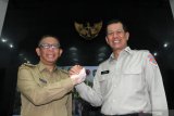 Kepala Badan Nasional Penanggulangan Bencana Daerah (BNPB) Doni Monardo (kiri) berjabat tangan dengan Gubernur Kalimantan Barat Sutarmidji (kiri) saat rapat koordinasi penanganan kebakaran hutan dan lahan (karhutla) di Pontianak, Kalimantan Barat, Senin (5/8/2019). Doni Monardo meminta kepada jajaran Pemerintah Provinsi Kalbar untuk melakukan pendekatan persuasif kepada masyarakat guna memberi pemahaman tentang kesiapsiagaan dalam mencegah serta mengatasi karhutla. ANTARA FOTO/Jessica Helena WuysangANTARA FOTO/JESSICA HELENA WUYSANG (ANTARA FOTO/JESSICA HELENA WUYSANG)