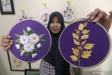 Perajin memperlihatkan lukis sulam berbingkai bulat (hoop art) karyanya di Desa Sukorejo Kediri, Jawa Timur, Jumat (9/8/2019). Seni lukis sulam tersebut dijual secara daring dengan harga Rp70 ribu hingga Rp2 juta per buah. Antara Jatim/Prasetia Fauzani/zk