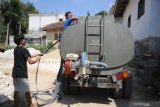 Pedagang menyiapkan selang untuk memasukkan air ke dalam penampungan  di Desa Tlonto Ares, Pamekasan, Jawa Timur, Sabtu (10/8/2019). Pada musim kemarau tahun ini, warga di daerah itu terpaksa membeli air bersih Rp150 ribu hingga Rp200 ribu per tangki isi 5.500 liter. Antara Jatim/Saiful Bahri/zk.
