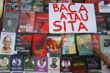 Pengunjung membaca buku dalam Lapak Buku Solidaritas, di Taman Merjosari, Malang, Jawa Timur, Sabtu (10/8/2019). Kegiatan  tersebut merupakan aksi solidaritas terhadap razia buku di sejumlah daerah yang dinilai merupakan pembungkaman terhadap budaya literasi . ANTARA FOTO/Ari Bowo SuciptoANTARA FOTO/ARI BOWO SUCIPTO (ANTARA FOTO/ARI BOWO SUCIPTO)