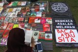 Pengunjung membaca buku dalam Lapak Buku Solidaritas, di Taman Merjosari, Malang, Jawa Timur, Sabtu (10/8/2019). Kegiatan  tersebut merupakan aksi solidaritas terhadap razia buku di sejumlah daerah yang dinilai merupakan pembungkaman terhadap budaya literasi . Antara Jatim/Ari Bowo Sucipto/zk.