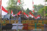 Warga melintas di bendera merah putih yang terbentang di sungai duyung kuin cerucuk, Banjarmasin, Kalimantan Selatan, Minggu (11/8/2019).Dalam rangka menyemarakkan HUT ke-74 Republik Indonesia warga kuin cerucuk Banjarmasin memasang bendera Merah Putih sepanjang 100 meter diatas sungai Duyung Kuin Cerucuk dan berbagai macam pernak pernik kemerdekaan.Foto Antaranews Kalsel/Bayu Pratama S.