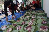 Warga menata daging kurban diatas daun pisang dan daun jati di Blitar, Jawa Timur, Minggu (11/8/2019). Sejumlah warga dan instansi didaerah tersebut memanfaatkan dedaunan dan wadah dari anyaman bambu (besek) untuk membungkus daging kurban yang bertujuan untuk mendukung program pemerintah dalam meminimalisir penggunaan plastik (diet plastik). Antara Jatim/Irfan Anshori/zk.