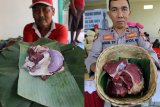 Foto kolase warga dan seorang anggota polisi menunjukkan daging kurban yang dibungkus tanpa menggunakan plastik di Blitar, Jawa Timur, Minggu (11/8/2019). Sejumlah warga dan instansi didaerah tersebut memanfaatkan dedaunan dan wadah dari anyaman bambu (besek) untuk membungkus daging kurban yang bertujuan untuk mendukung program pemerintah dalam meminimalisir penggunaan plastik (diet plastik). Antara Jatim/Irfan Anshori/zk.