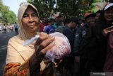 Warga menunjukkan sekantung daging kurban yang didapatnya di Pengadilan Negeri Surabaya, Jawa Timur, Minggu (11/8/2019). Pada Hari Raya Idul Adha 1440 Hijriah Pengadilan Negeri Surabaya membagikan sekitar 2.500 bungkus daging kurban untuk masyarakat sekitar. Antara Jatim/Didik Suhartono/ZK