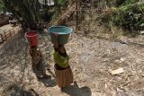 Warga memanggul air bersih di Desa Silomukti, Mlandingan, Situbondo, Jawa Timur, Senin (12/8/2019). BPBD Situbondo mendistribusikan air bersih ke lima desa di empat kecamatan yang mengalami kesulitan air bersih dan BPBD kewalahan mendistribusikan air bersih karena keterbatasan armada truk tangki cuma satu unit. Antara Jatim/Seno/zk.