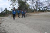Sejumlah siswa pulang sekolah melewati jalan berdebu dari SD 'kelas jauh' (Filial) Dusun Cobbuk yang menginduk di SDN 8 Curah Tatal, Arjasa, Situbondo, Jawa Timur, Selasa (13/8/2019). Puluhan siswa SD Filial tersebut berangkat dan pulang sekolah melewati jalan rusak, berdebu sekitar 3 kilometer perjalanan. Antara Jatim/Seno/zk
