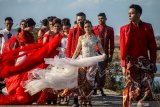 Model mengenakan busana kebaya bertema merah putih saat fashion show di tanggul lapindo Porong, Sidoarjo, Jawa Timur, Selasa (13/8/2019).Peragaan busana yang menampilkan busana kebaya tersebut untuk memeriahkan HUT ke-74 kemerdekaan RI. Antara Jatim/Umarul Faruq/zk