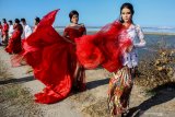 Model mengenakan busana kebaya bertema merah putih saat fashion show di tanggul lapindo Porong, Sidoarjo, Jawa Timur, Selasa (13/8/2019). Peragaan busana yang menampilkan busana kebaya tersebut untuk memeriahkan HUT ke-74 kemerdekaan RI. Antara Jatim/Umarul Faruq/zk