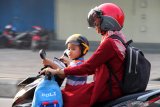 PEMKOT PONTIANAK LIBURKAN SEKOLAH. Seorang anak menaiki motor saat melintasi Jalan Ahmad Yani Pontianak, Kalimantan Barat, Selasa (13/8/2019). Pemerintah Kota Pontianak meliburkan siswa Sekolah Dasar, Taman Kanak-Kanak dan Pendidikan Anak Usia Dini (PAUD) selama dua hari yaitu Selasa (13/8) dan Rabu (14/8), menyusul semakin buruknya kondisi cuaca akibat polusi asap dari kebakaran hutan dan lahan (karhutla) yang melanda Kota Pontianak dengan Indeks Standard Pencemaran Udara (ISPU) 150 atau tidak sehat. ANTARA FOTO/Jessica Helena WuysangJESSICA HELENA WUYSANG/JESSICA HELENA WUYSANG (JESSICA HELENA WUYSANG/JESSICA HELENA WUYSANG)