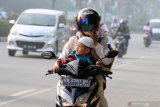 PEMKOT PONTIANAK LIBURKAN SEKOLAH. Seorang anak menaiki motor saat melintasi Jalan Ahmad Yani Pontianak, Kalimantan Barat, Selasa (13/8/2019). Pemerintah Kota Pontianak meliburkan siswa Sekolah Dasar, Taman Kanak-Kanak dan Pendidikan Anak Usia Dini (PAUD) selama dua hari yaitu Selasa (13/8) dan Rabu (14/8), menyusul semakin buruknya kondisi cuaca akibat polusi asap dari kebakaran hutan dan lahan (karhutla) yang melanda Kota Pontianak dengan Indeks Standard Pencemaran Udara (ISPU) 150 atau tidak sehat. ANTARA FOTO/Jessica Helena WuysangJESSICA HELENA WUYSANG/JESSICA HELENA WUYSANG (JESSICA HELENA WUYSANG/JESSICA HELENA WUYSANG)