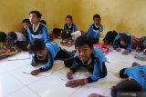 Sejumlah siswa belajar di lantai kelas SD 'kelas jauh' (Filial) Dusun Cobbuk yang menginduk di SDN 8 Curah Tatal, Arjasa, Situbondo, Jawa Timur, Selasa (13/8/2019). Kegiatan belajar mengajar di SD terpaksa di lantai karena sekolah tidak memiliki meja dan kursi dalam setahun terakhir. Antara Jatim/Seno/zk