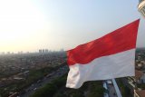 Foto aerial bendera Merah Putih super akbar berkibar di menara Masjid Al Akbar Surabaya, Kamis, (15/08/2019). Pengibaran bendera Merah Putih dengan berat 45 kilogram tersebut dilakukan oleh 99 orang dalam rangka menyambut HUT ke-74 Kemerdekaan Republik Indonesia. Antara Jatim/Naufal Ammar/zk.