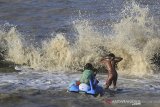 Sejumlah anak bermain di antara ombak di pantai Juntinyuat, Indramayu, Jawa Barat, Selasa (13/8/2019). BMKG menyatakan gelombang di perairan laut Jawa mencapai 3 meter akibat angin kencang. ANTARA FOTO/Dedhez Anggara/agr