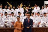 Presiden Joko Widodo (kanan) didampingi Ibu Negara Iriana Joko Widodo (kiri) bersiap untuk berfoto bersama dengan anggota Pasukan Pengibar Bendera Pusaka (Paskibraka) usai upacara pengukuhan di Istana Negara Jakarta, Kamis (15/8/2019). Presiden Joko Widodo mengukuhkan 68 anggota Paskibraka yang akan bertugas pada upacara HUT ke-74 Kemerdekaan RI. ANTARA FOTO/Wahyu Putro A/nym.