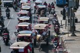 Warga menaiki delman hias pada acara Karnaval delman merah putih di kawasan Alun-alun Bandung, Jawa Barat, Kamis (15/8/2019). Kegiatan karnaval delman merah putih tersebut bertujuan untuk memeriahkan dan menyambut HUT Ke-74 Kemerdekaan RI. ANTARA FOTO/Novrian Arbi/agr