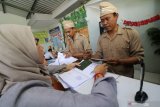 Petugas berkostum pejuang kemerdekaan melayani pemohon paspor di kantor Imigrasi kelas III Non Tempat Pemeriksaan Imigrasi (TPI), Kediri, Jawa Timur, Kamis (15/8/2019). Seluruh petugas di kantor tersebut setiap hari Kamis pada bulan Agustus memakai kostum pejuang guna memeriahkan hut kemerdekaan ke-74 Bangsa Indonesia. Antara Jatim/Prasetia Fauzani/zk