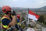 Teknisi dari PT. XL Axiata Tbk melakukan penghormatan kepada bendera merah putih saat pengibaran bendera di puncak menara BTS setinggi 50 meter di Cikole, Lembang, Kabupaten Bandung Barat, Jawa Barat, Kamis (15/8/2019). Pengibaran bendera tersebut dilakukan dalam rangka memeriahkan HUT ke-74 kemerdekaan RI. ANTARA FOTO/Raisan Al Farisi/agr